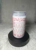 A white insulated tumbler with a clear lid, decorated with a pink leopard print and the word 'MAMA' in a pink square frame, displayed on a black circular base against a soft gray background.